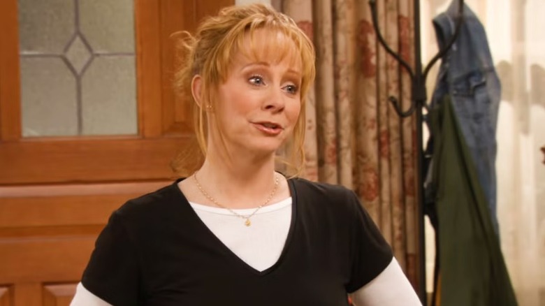 Reba Hart standing near a door in "Reba"