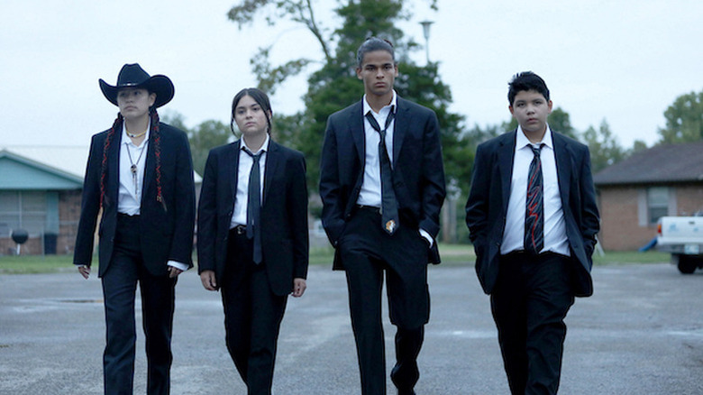 Cheese, Elora, Willie Jack and Bear walking down the street in suits in Reservation Dogs