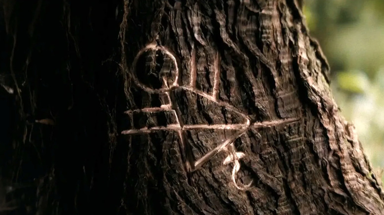 Yellowjackets, the wilderness symbol carved into tree