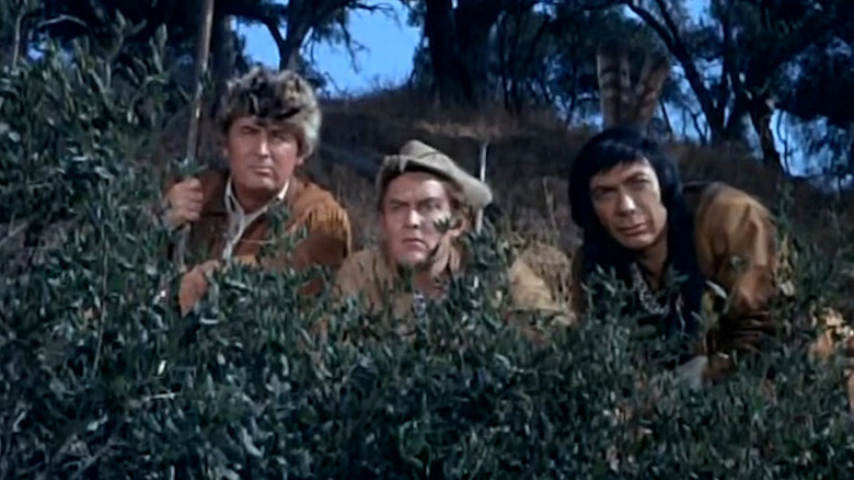 Fess Parker as Daniel Boone, Jimmy Dean as Josh Clements, and Ed Ames as Mingo hiding behind the bushes in Daniel Boone