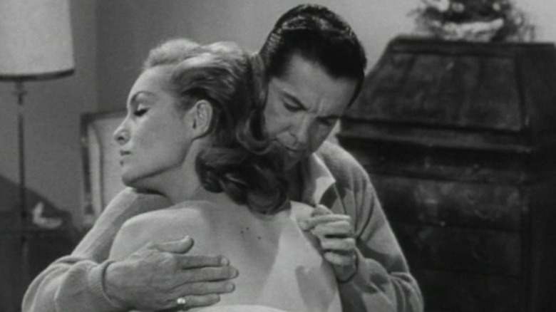 Bob Cummings as Bob with arms around Julie Newmar as Rhoda, who is leaning into him, in My Living Doll