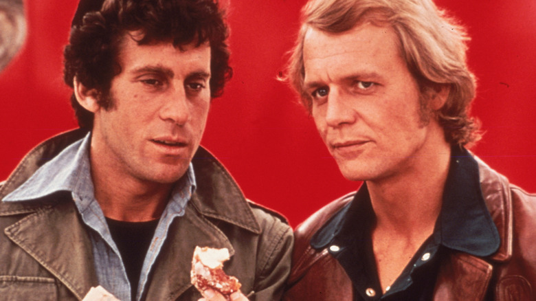 David Starsky holds a donut standing beside Ken "Hutch" Hutchinson in the television series Starsky & Hutch (1977).