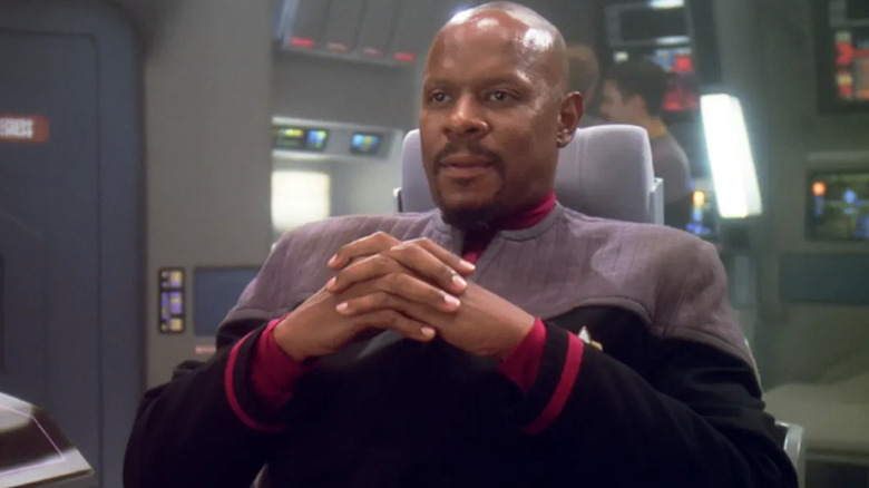 Avery Brooks as Benjamin Sisko holds his hands together in Star Trek: Deep Space Nine