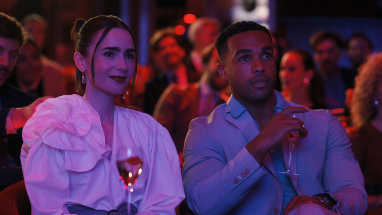 Emily sitting next to Alfie in a crowd