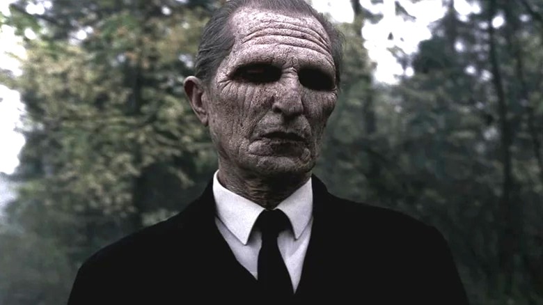 Alex Diakun's Reaper wearing a black suit and tie on Supernatural