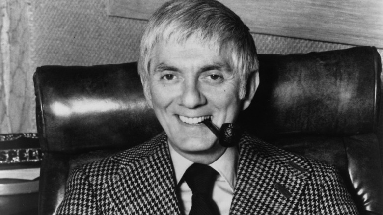 Executive producer Aaron Spelling seated behind desk and smiling