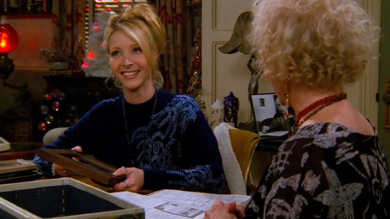 Lisa Kudrow as Phoebe Buffay, looking through a box on Friends.
