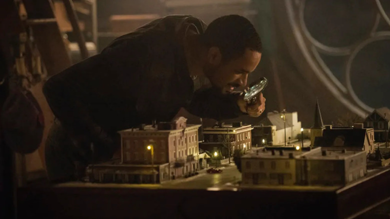Jason Grant (Damon Wayans Jr.) examines a model town with a magnifying glass in The Twilight Zone