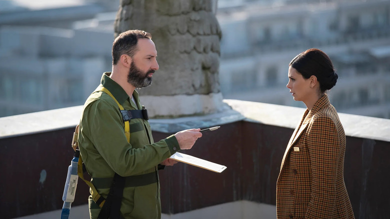 Tom (Tony Hale) offers a signup sheet to Michelle Weaver (Morena Baccarin) in The Twilight Zone