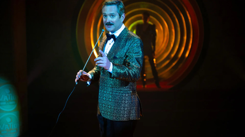 J.J. Malloy (Thomas Lennon) introduces Jasmine Delancey (Jurnee Smollett) on stage in The Twilight Zone