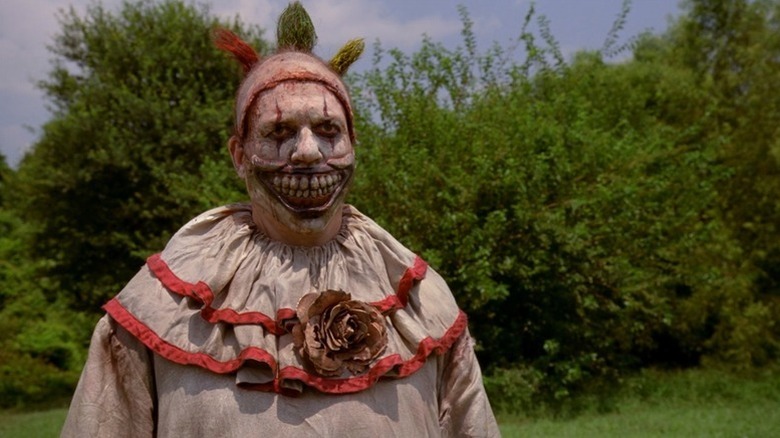 John Carroll Lynch's Twisty the Clown wearing his scary clown costume outdoors on American Horror Story