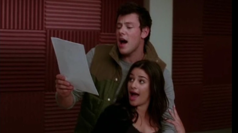 Lea Michele's Rachel and Mark Saling's Puck singing from a sheet on Glee