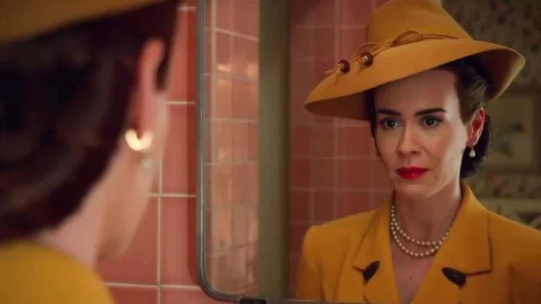 Sarah Paulson's Mildred Ratched wearing yellow and looking in the mirror on Ratched