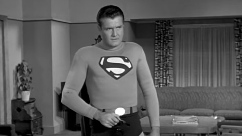 George Reeves as Superman, walking through a living room in Adventures of Superman.