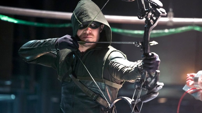 Stephen Amell as the Arrow, aiming his bow in Arrow.