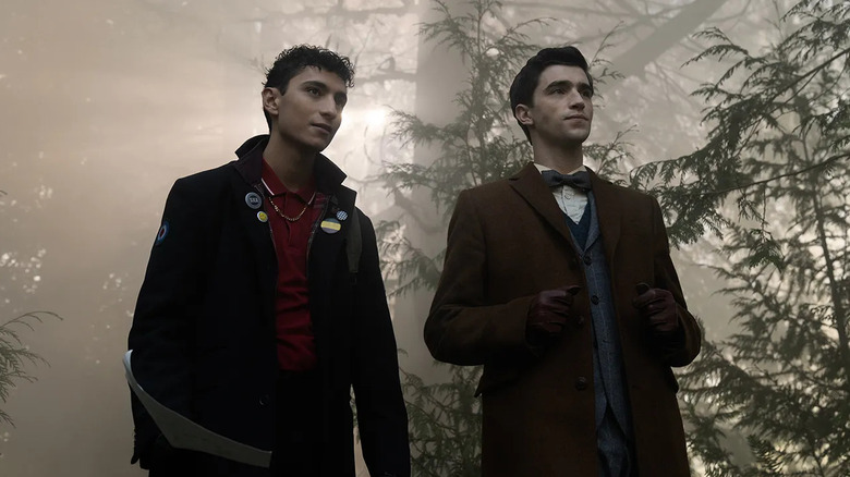 Jayden Revri as Charles Rowland and George Rexstrew as Edwin Payne, walking through the woods in Dead Boy Detectives.