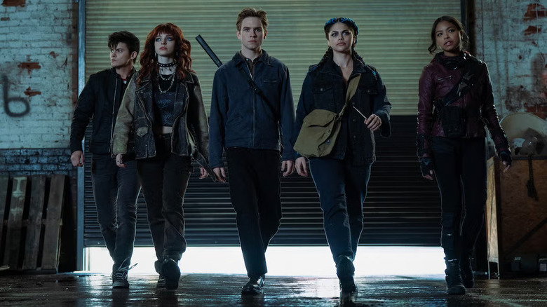 The ensemble of Gotham Knights walking through a garage in Gotham Knights.