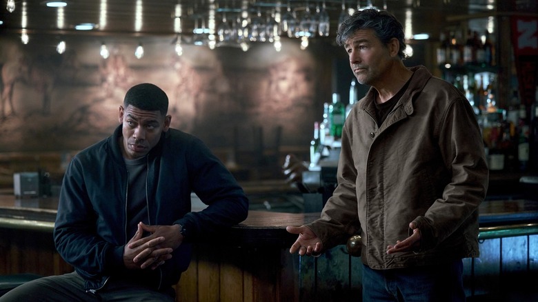 Aaron Pierre as John Stewart and Kyle Chandler as Hal Jordan, asking questions in a bar in Lanterns.