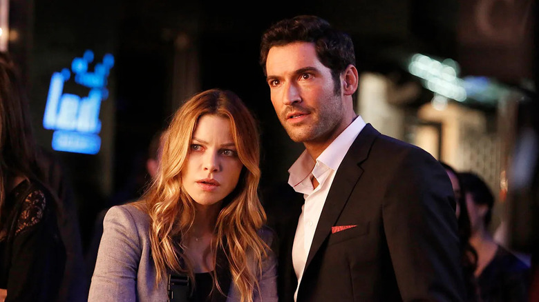 Tom Ellis as Lucifer Morningstar and Lauren German as Chloe Decker, standing together in a club in Lucifer.
