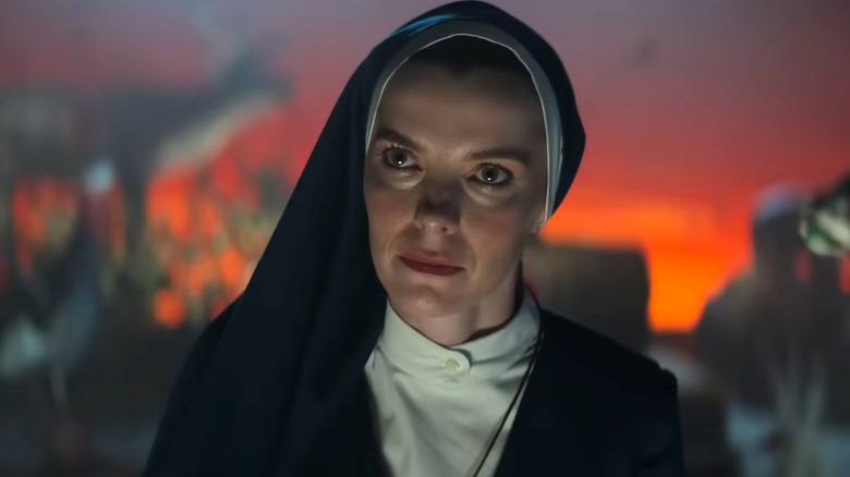 Betty Gilpin as Sister Simone in "Mrs Davis" wearing a blue habit and white button shirt.