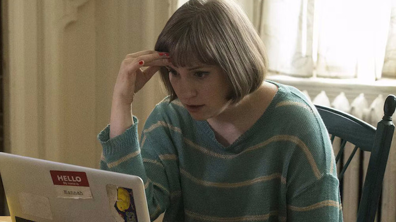 Hannah looks at her computer while sitting at a table in her Iowa home on Girls