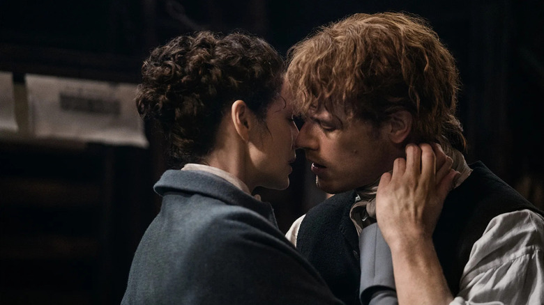 Claire Fraser (Caitríona Balfe) goes in for a tender kiss with Jamie Fraser (Sam Heughan) in Outlander