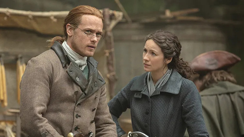 Claire Fraser (Caitríona Balfe) glances at Jamie Fraser (Sam Heughan) in Outlander