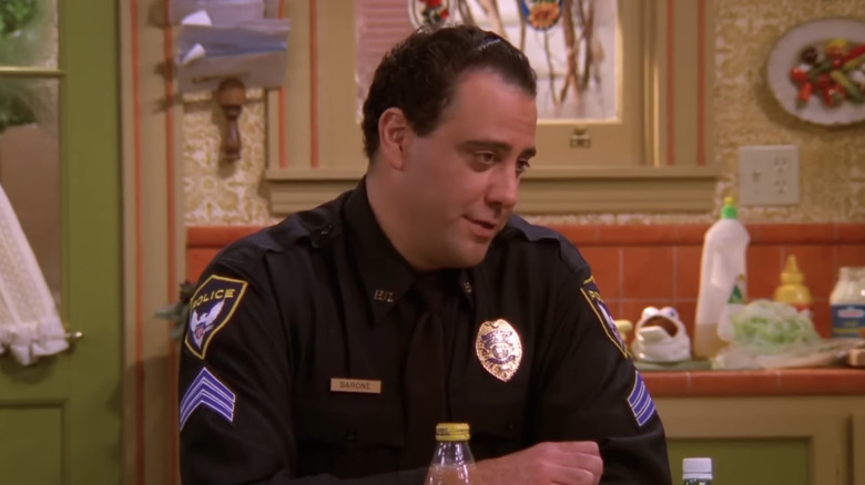 Brad Garrett as Robert sits at a table in Everybody Loves Raymond