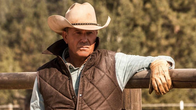 Kevin Costner as John Dutton leans on a fence in Yellowstone