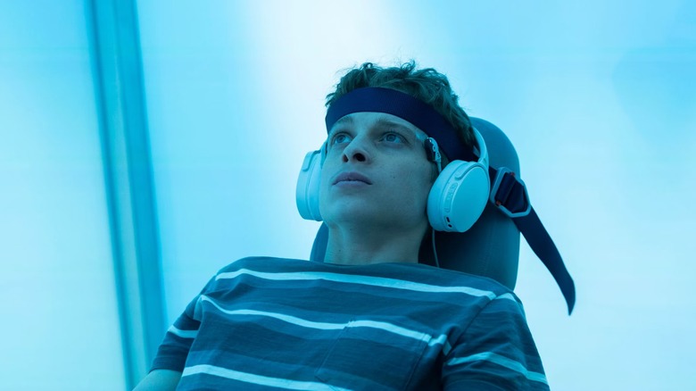 Luke Ellis sitting on a chair and wearing headphones on "The Institute"