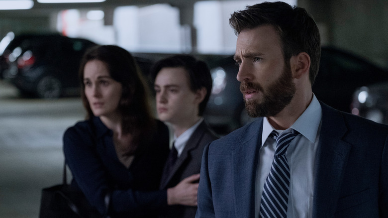 Michelle Dockery, Jaeden Martell, and Chris Evans as the Barbers standing in a parking garage in Defending Jacob
