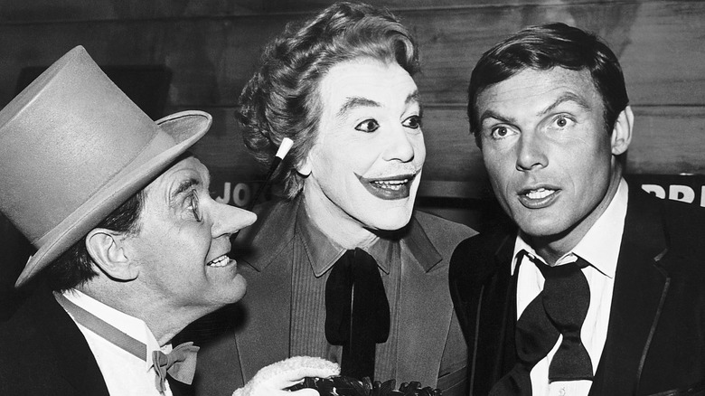 A black-and-white image of Burgess Meredith as The Penguin, Cesar Romero as The Joker, and Adam West as Bruce Wayne/Batman.