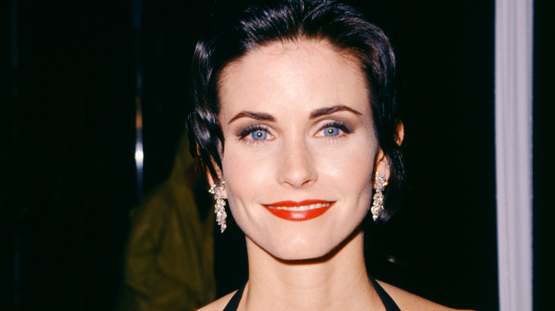 Courteney Cox smiling at event in the '90s