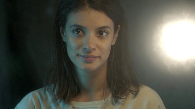 Glow in a white hospital outfit standing next to a light orb in The Gifted
