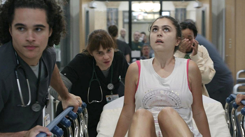 Jenna Burke (Mika Abdalla) being wheeled through the hospital in "The Pitt" Season 1