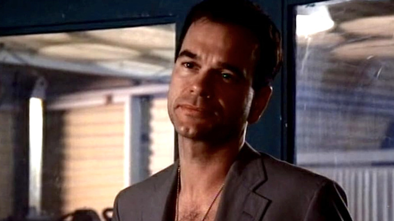 Captain Dick Richard in a gray suit jacket and necklace standing in a hospital in China Beach