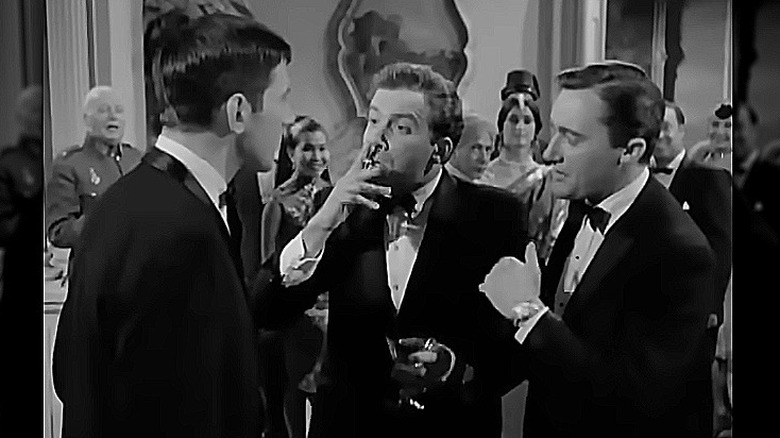 William Shatner smoking a cigarette while looking at Leonard Nimoy in a scene from The Man from U.N.C.L.E.