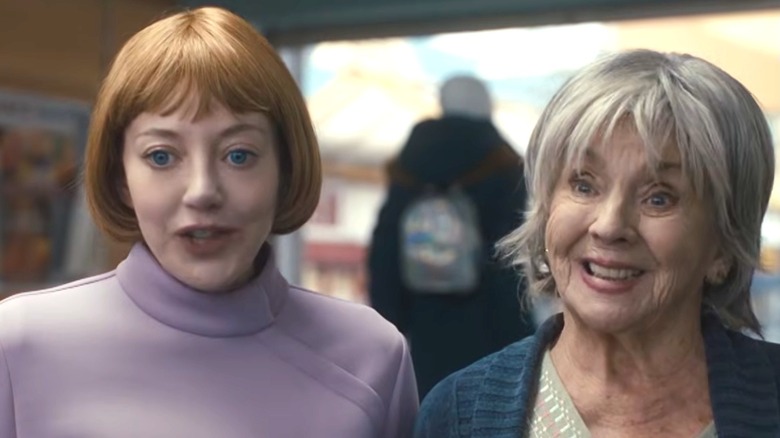 Linda speaking and standing next to Sue, who is smiling