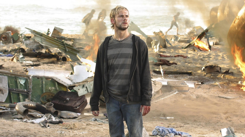 Charlie stands amidst plane wreckage on beach