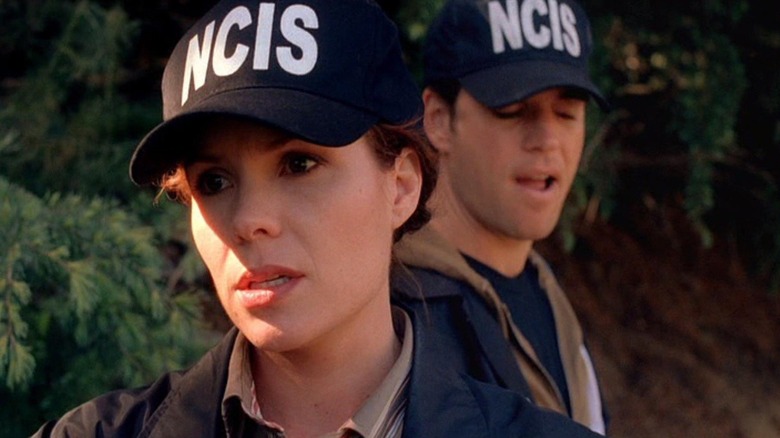Vivian Blackadder (Robyn Lively) stands outside with Tony DiNozzo (Michael Weatherly) making a face behind her in JAG