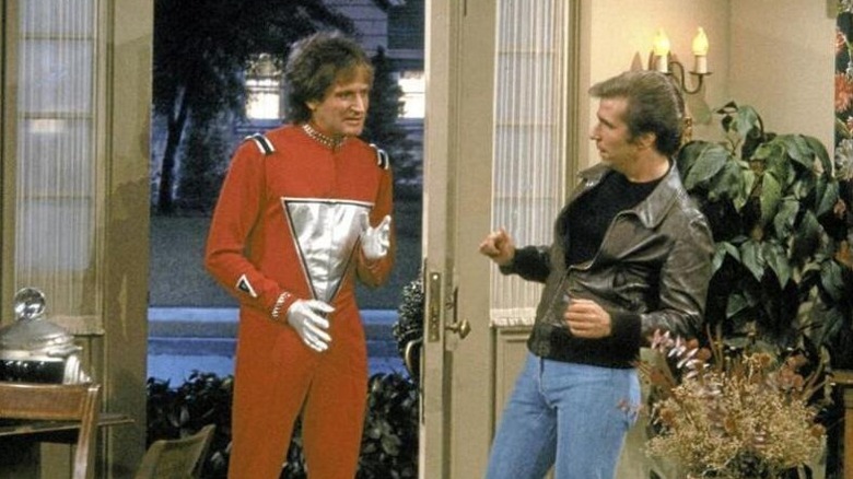 Mork (Robin Williams) walks into a house surprising Fonzie (Henry Winkler) in Happy Days