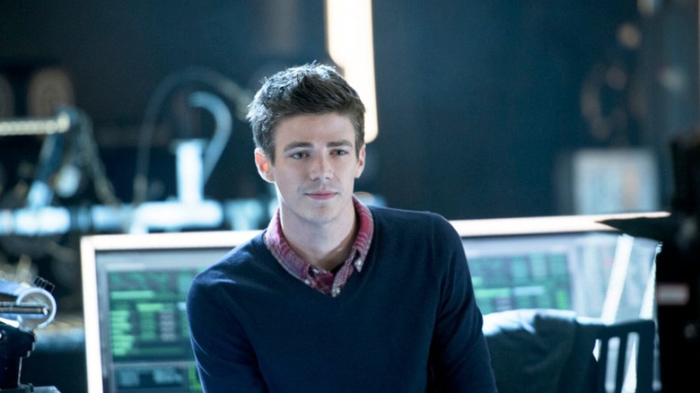 Barry Allen (Grant Gustin) sits at a desk in Arrow