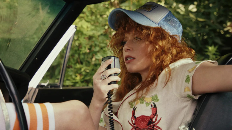 Natasha Lyonne as Charlie Cale in a car using a radio in "Poker Face."