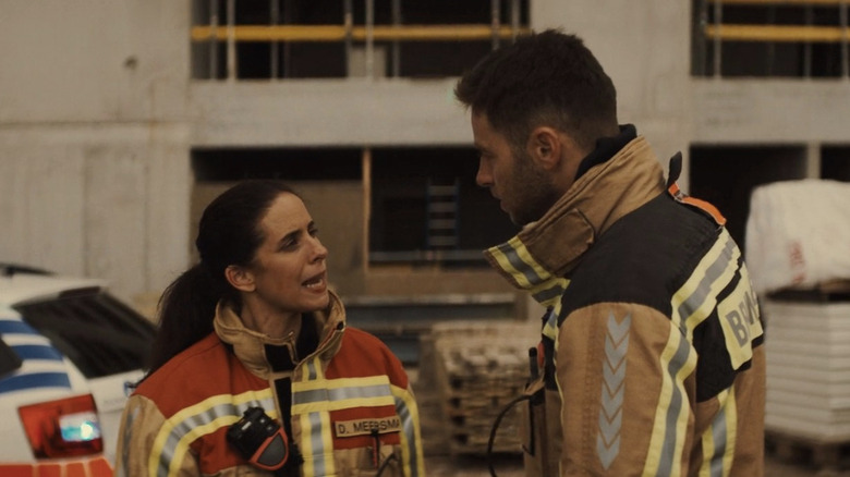 Lien De Grave as Dominique Meersman talking to Louis Talpe as Orlando Foncke in firefighter gear in Under Fire
