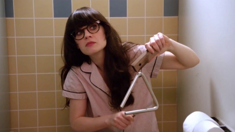 Jess (Zooey Deschanel) plays the triangle in the bathroom in New Girl