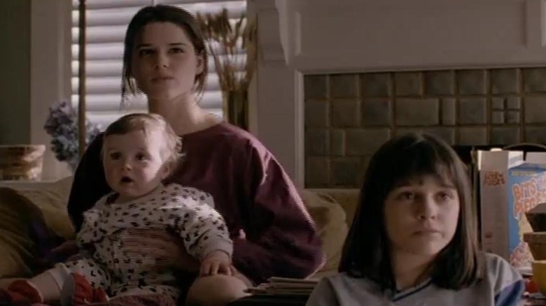 Julia (Neve Campbell) holds Owen while Claudia (Lacey Chabert) sits on the floor in Party of Five