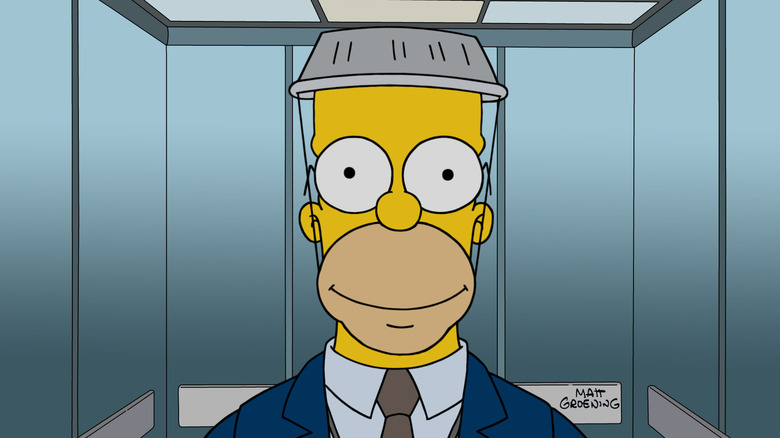 Homer Simpson (Dan Castellaneta) smiles with a pie tin hat in The Simpsons