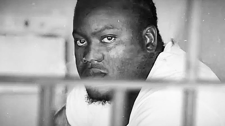 A man looks through prison bars in 13th.
