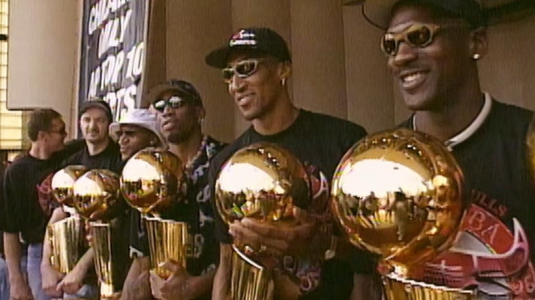 Bulls players hold trophies in front of the press in The Last Dance.
