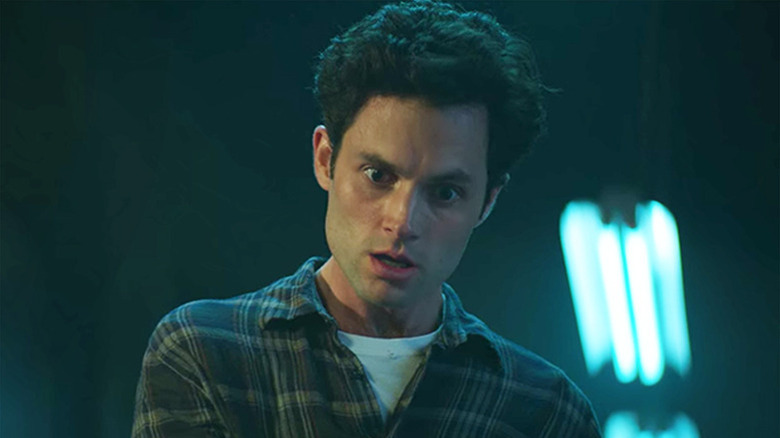 Penn Badgley as Joe wearing flannel with deranged face in You